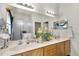 Elegant bathroom featuring double sinks, granite countertops, and a glass-enclosed shower for a spa-like experience at 3819 Saint Emma Ct, Leesburg, FL 34748