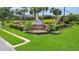 A community sign framed by a water feature and lush landscaping, surrounded by homes and trees at 3819 Saint Emma Ct, Leesburg, FL 34748