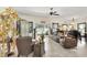 Open-concept living room with ornate decor, tile flooring, and backyard views through large windows at 3819 Saint Emma Ct, Leesburg, FL 34748