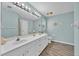 Bathroom featuring double sinks, modern fixtures, and wood-look floors at 39 Pine Court Dr, Ocala, FL 34472