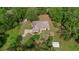Expansive aerial view of a single-Gathering home with a large yard, surrounded by mature trees and manicured landscaping at 39132 Grays Airport Rd, Lady Lake, FL 32159