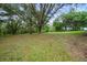 Expansive backyard showcases mature trees and lush greenery, offering serene privacy at 39132 Grays Airport Rd, Lady Lake, FL 32159