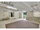 A well-lit, unfinished basement with an open door and access to the backyard, featuring white-painted walls at 39132 Grays Airport Rd, Lady Lake, FL 32159