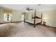 Bright bedroom with a four-poster bed, windows with curtains, and a large floor area at 39132 Grays Airport Rd, Lady Lake, FL 32159