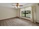 Bright and airy bedroom with neutral carpet, a large window, and serene view of the outdoors at 39132 Grays Airport Rd, Lady Lake, FL 32159