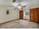 Bedroom with neutral colored carpet, ceiling fan and wooden bi-fold closet doors at 39132 Grays Airport Rd, Lady Lake, FL 32159