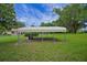 Carport in backyard with green lawn and mature trees at 39132 Grays Airport Rd, Lady Lake, FL 32159