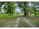 Long driveway leading to the property, surrounded by mature trees at 39132 Grays Airport Rd, Lady Lake, FL 32159