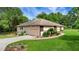 Captivating view of the home featuring a side-entry garage, lush lawn and detailed landscaping around the property at 39132 Grays Airport Rd, Lady Lake, FL 32159