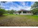 A serene exterior view of the home with well manicured lawn and mature landscaping at 39132 Grays Airport Rd, Lady Lake, FL 32159
