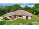 Attractive single-story home with a well-manicured front lawn, inviting entrance, and mature trees around the property at 39132 Grays Airport Rd, Lady Lake, FL 32159