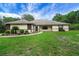 Well-manicured front yard with lush lawn, shrubbery, and sidewalk at 39132 Grays Airport Rd, Lady Lake, FL 32159