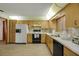Well-lit kitchen features light wood cabinets, black appliances, and tile flooring at 39132 Grays Airport Rd, Lady Lake, FL 32159