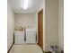 Functional laundry room with a washer, dryer, storage, and a tiled floor at 39132 Grays Airport Rd, Lady Lake, FL 32159