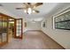 Expansive living room features a large window, carpet floors, and an elegant ceiling fan at 39132 Grays Airport Rd, Lady Lake, FL 32159
