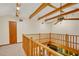 A cozy loft area featuring wooden beams, railing, and a ceiling fan at 39132 Grays Airport Rd, Lady Lake, FL 32159
