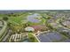Aerial view of community clubhouse, pool, tennis court, parking lot, golf course and pond at 3978 Nottingham Loop, The Villages, FL 32163