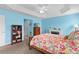 Cozy bedroom features a floral comforter, a small fireplace, bright blue walls, and natural light from the windows at 3978 Nottingham Loop, The Villages, FL 32163