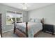 Comfortable bedroom features a ceiling fan and large window at 3978 Nottingham Loop, The Villages, FL 32163