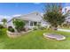 Beautifully landscaped front yard with mature trees, flower beds, and a well-maintained lawn at 3978 Nottingham Loop, The Villages, FL 32163
