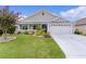 Charming single-story home with a well-manicured lawn, flower beds, and an attached two-car garage at 3978 Nottingham Loop, The Villages, FL 32163