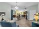 Open-concept living room with hardwood floors, ceiling fan, lots of seating and a view of the kitchen at 3978 Nottingham Loop, The Villages, FL 32163