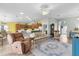 Open-concept living room and kitchen with hardwood floors, ceiling fan, lots of seating and bar top dining at 3978 Nottingham Loop, The Villages, FL 32163
