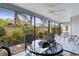 Screened patio with ceiling fan, outdoor furniture, and view of a lush backyard with landscaping at 3978 Nottingham Loop, The Villages, FL 32163