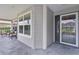 Covered front porch featuring a slate-tiled floor, seating, and a front door with sidelight window at 3978 Nottingham Loop, The Villages, FL 32163