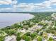 Aerial view of the residential neighborhood with tree-lined streets and lake front property under a blue partly cloudy sky at 400 W Washington St, Minneola, FL 34715