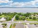 An aerial view showcases a home next to a large lake, highlighting nearby homes and surrounding lush greenery at 400 W Washington St, Minneola, FL 34715