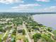 Panoramic aerial view captures the neighborhood, the lake, and waterfront homes surrounded by lush greenery at 400 W Washington St, Minneola, FL 34715