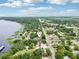 Birds-eye view of the neighborhood with marker on property; lush greenery and waterfront homes lining the tranquil lake under a partly cloudy sky at 400 W Washington St, Minneola, FL 34715