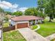 Charming single-story home with a brown roof, stone accents, and a well-manicured front yard at 400 W Washington St, Minneola, FL 34715