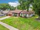 Well-kept single-story home featuring stone accents, a brown roof, and a lush green lawn at 400 W Washington St, Minneola, FL 34715