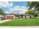 Charming single-story home with lush green lawn, stone accents and a red front door at 400 W Washington St, Minneola, FL 34715