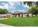 Charming single-story home with a well-manicured lawn, stone accents, and a red front door at 400 W Washington St, Minneola, FL 34715
