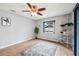 A bright room features wood-look flooring, a ceiling fan, a window, and a modern metal shelf at 400 W Washington St, Minneola, FL 34715