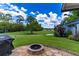 Beautiful backyard with a stone firepit, grill, and an expansive green lawn at 4634 Bigler Ln, Mount Dora, FL 32757