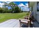Backyard patio with rocking chairs offering views of the lush green lawn and lake at 4634 Bigler Ln, Mount Dora, FL 32757