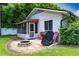 Private backyard with a screened porch, fire pit area, and grilling area at 4634 Bigler Ln, Mount Dora, FL 32757