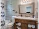 Charming bathroom with a wooden vanity, tiled shower, and decorative mirror at 4634 Bigler Ln, Mount Dora, FL 32757