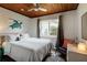 Cozy bedroom featuring a queen-sized bed, ceiling fan, and a turtle painting wall decoration at 4634 Bigler Ln, Mount Dora, FL 32757