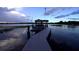 Lakeside dock with a covered boat lift and watercraft in a tranquil setting at 4634 Bigler Ln, Mount Dora, FL 32757