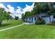 Charming single-story home featuring a well-manicured lawn, inviting front porch, and views of the water at 4634 Bigler Ln, Mount Dora, FL 32757