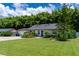 Charming home featuring a well-manicured front lawn, colorful landscaping and a bright blue front door at 4634 Bigler Ln, Mount Dora, FL 32757