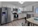 Modern kitchen with stainless steel appliances, white cabinets, and granite countertops at 4634 Bigler Ln, Mount Dora, FL 32757