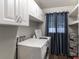 Functional laundry room with white cabinets, modern washer and dryer, and convenient shelving at 4634 Bigler Ln, Mount Dora, FL 32757