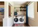 Bright laundry room with front loading washer and dryer and overhead shelving for storage at 4634 Bigler Ln, Mount Dora, FL 32757