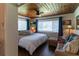 Cozy main bedroom with natural light, wood ceiling, and a sitting area by the windows at 4634 Bigler Ln, Mount Dora, FL 32757